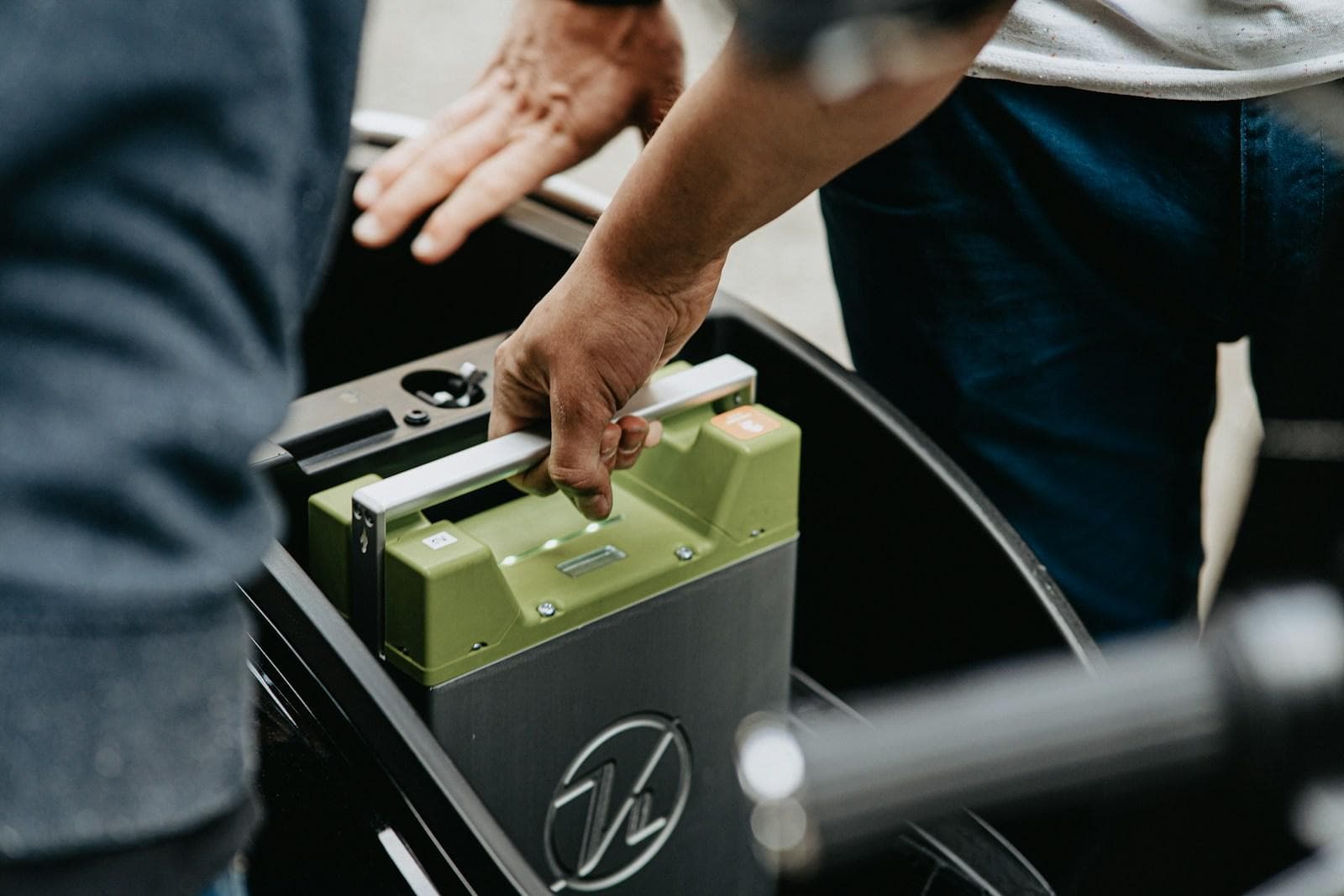 Car battery being lifted into an engine bay