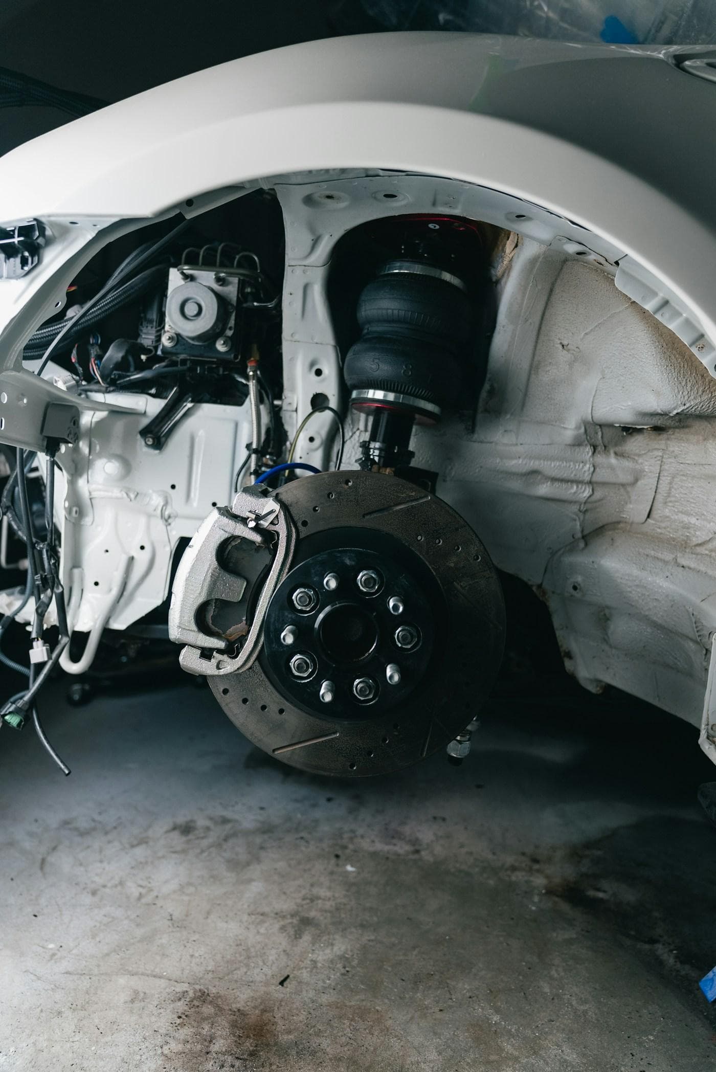 Front corner of a car stripped back to the brake disc and suspension