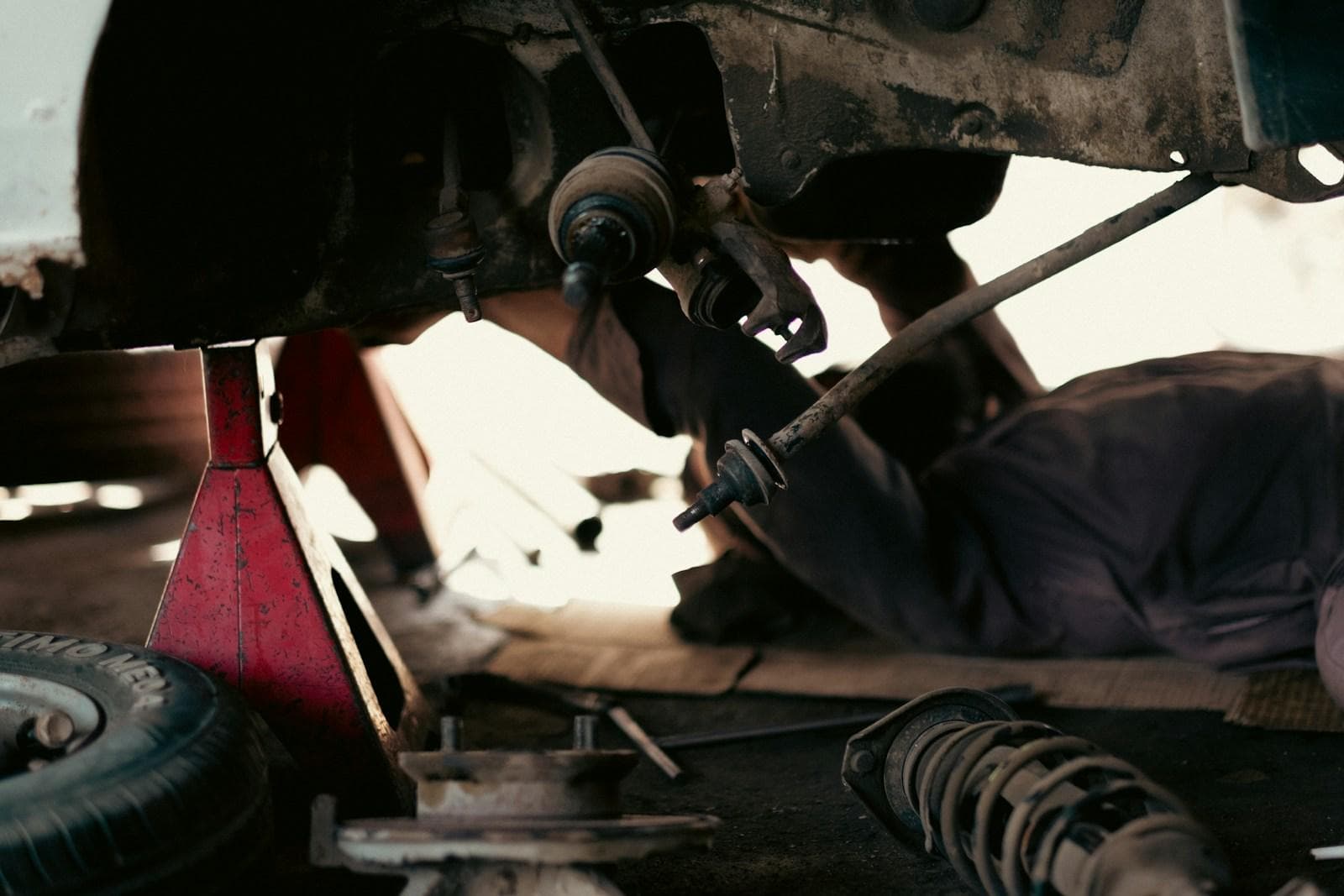 Mechanic underneath a vehicle working on the drivetrain